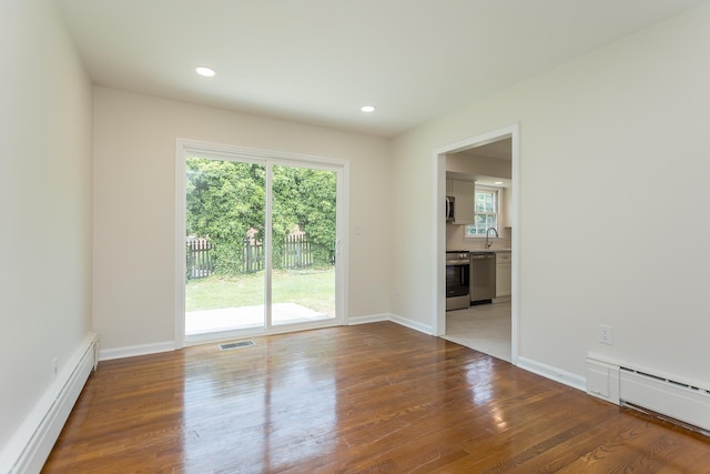 1002 Coalter St, Staunton, VA 24401 - empty room with a baseboard heating unit, wood finished floors, recessed lighting, and baseboards
