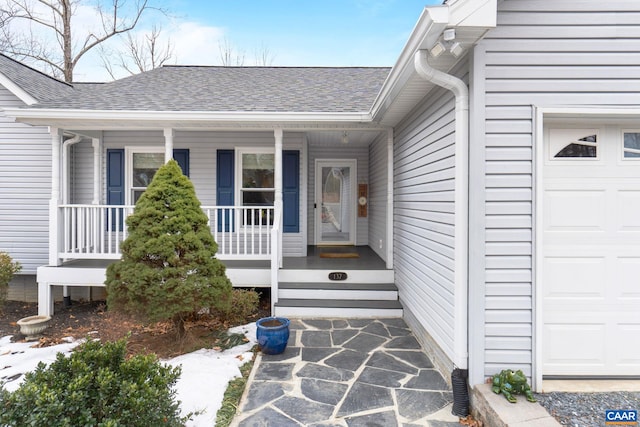 doorway to property with a shingled roof, covered porch, and an attached garage