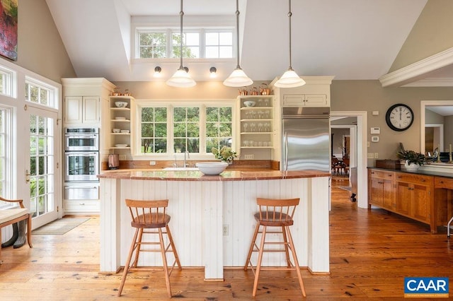 240 Broad Axe Rd, Charlottesville, VA 22903 - kitchen with open shelves, a warming drawer, light wood-style flooring, a center island, and appliances with stainless steel finishes