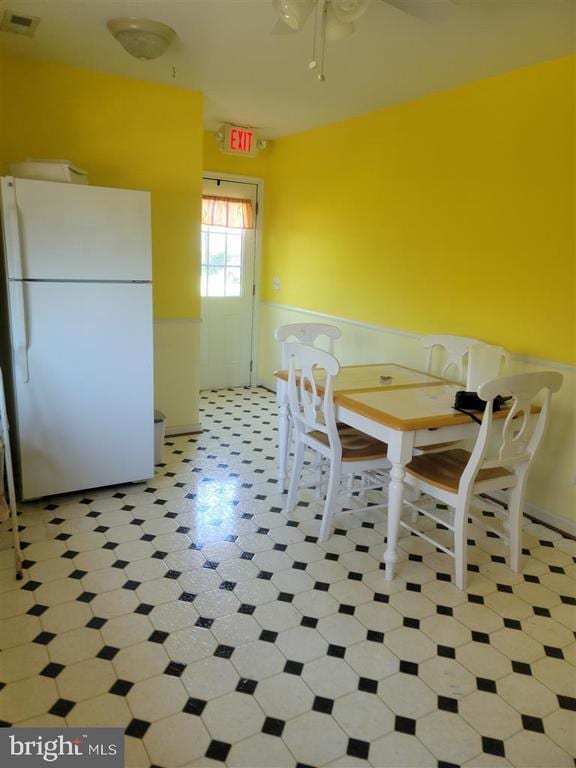 dining room with a wainscoted wall and a ceiling fan