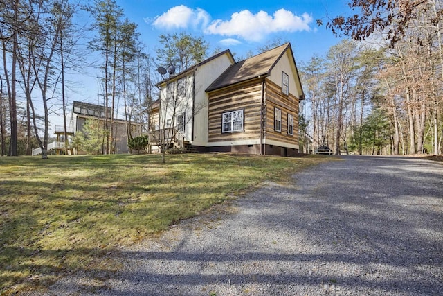view of property exterior featuring a yard and gravel driveway