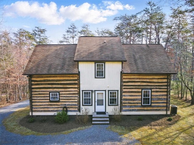 view of front of home featuring a shingled roof and log siding