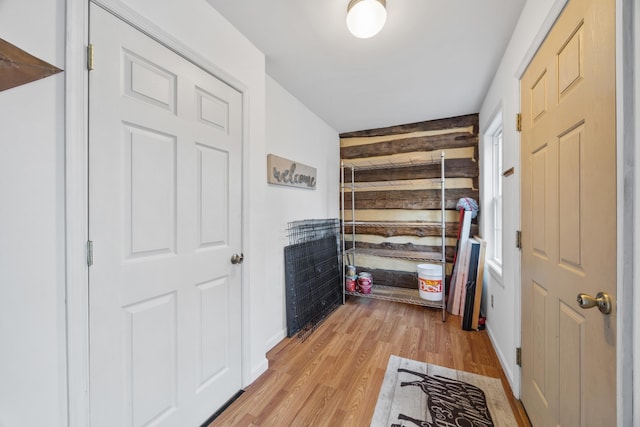interior space featuring light wood-type flooring and wooden walls