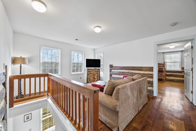 living room with a wealth of natural light, visible vents, and dark wood finished floors