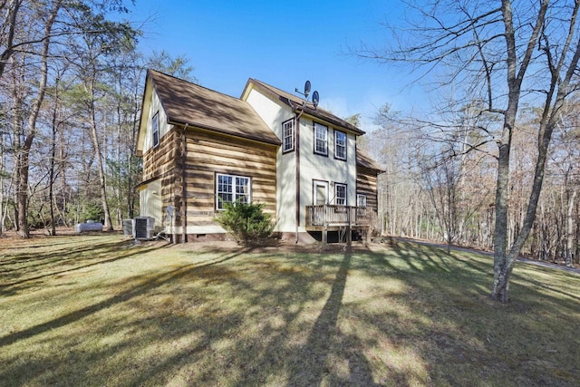 rear view of property with a yard and central AC