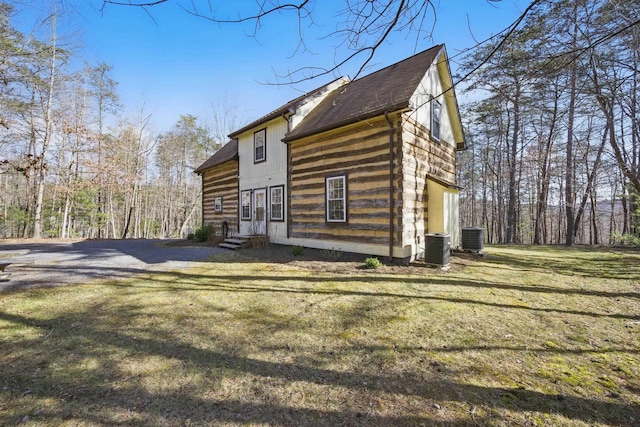 exterior space featuring a lawn, entry steps, roof with shingles, and central air condition unit