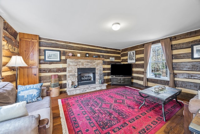 living area with wooden walls, wood finished floors, and a fireplace