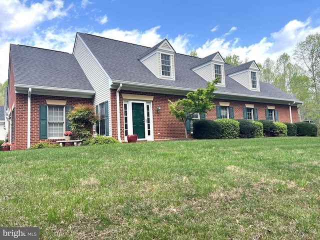 cape cod home with brick siding, a front lawn, and a shingled roof