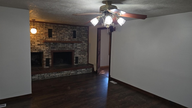 unfurnished living room with wood finished floors, a textured ceiling, a brick fireplace, a ceiling fan, and baseboards
