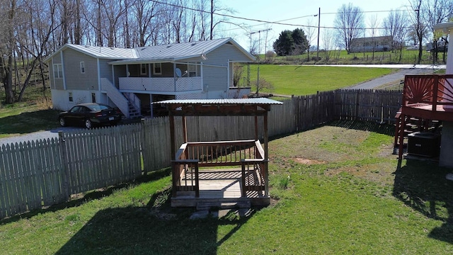 view of yard with central AC unit, a deck, and a fenced backyard