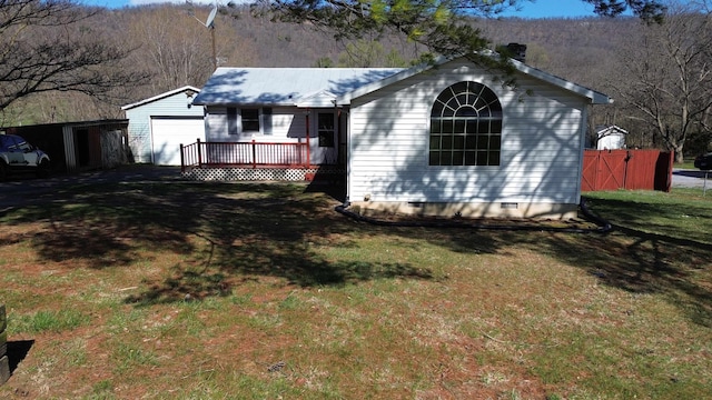 view of front facade with crawl space, fence, and a front yard