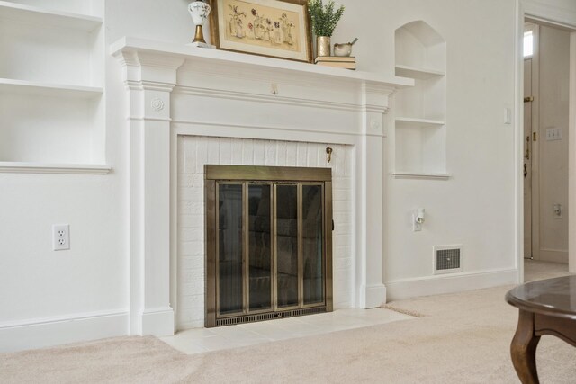 detailed view of carpet, a brick fireplace, built in shelves, and baseboards