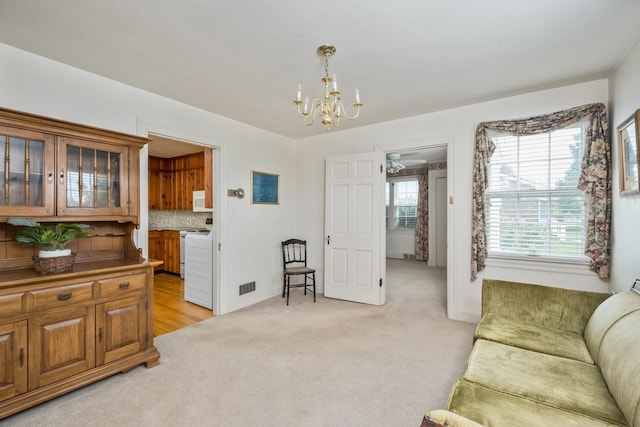 living room featuring a chandelier and light carpet