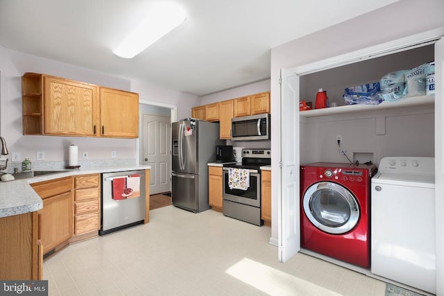 kitchen with open shelves, light countertops, separate washer and dryer, a sink, and appliances with stainless steel finishes