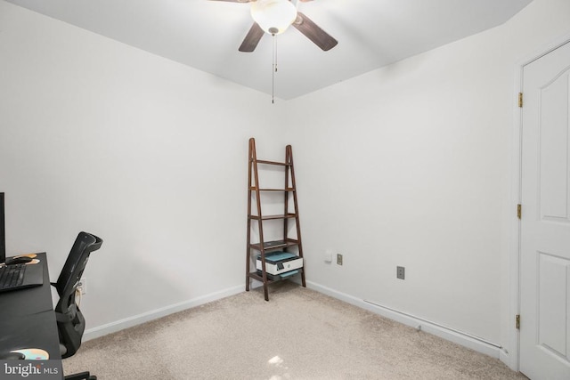 office space featuring baseboards, light carpet, and a ceiling fan