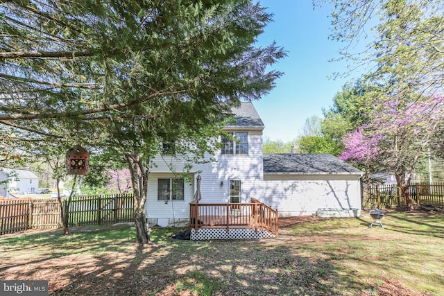 back of house featuring a lawn, a shingled roof, a wooden deck, and a fenced backyard