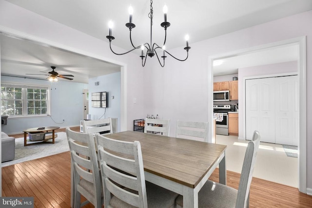 dining area featuring ceiling fan with notable chandelier and light wood-style floors