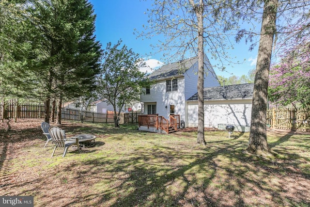 view of yard featuring a fenced backyard, an outdoor fire pit, and a wooden deck