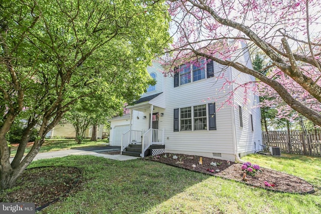 view of front facade featuring crawl space, a front yard, a garage, fence, and cooling unit