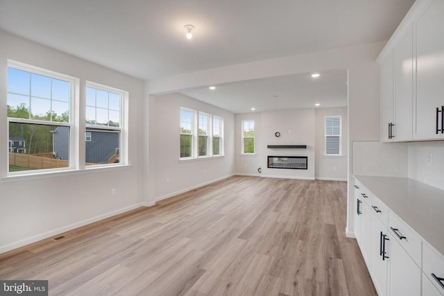 35663 Aspen Way, Locust Grove, VA 22508 - unfurnished living room with light wood-style floors, baseboards, recessed lighting, and a glass covered fireplace