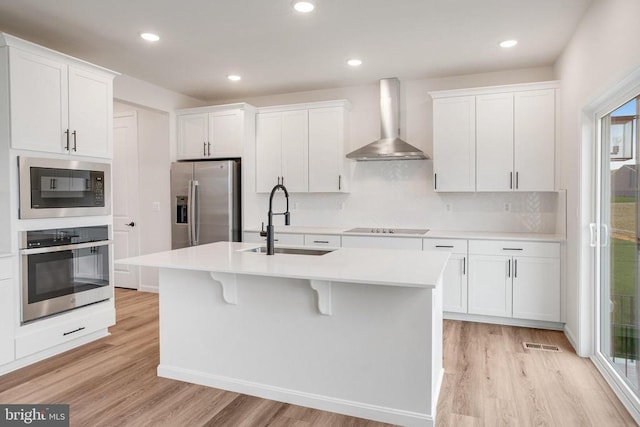 35663 Aspen Way, Locust Grove, VA 22508 - kitchen with wall chimney range hood, stainless steel appliances, a sink, light wood finished floors, and light countertops