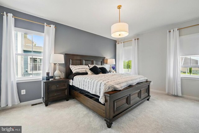 bedroom with light carpet and baseboards
