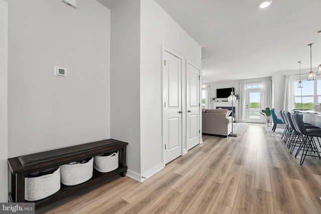 hall featuring light wood-type flooring, baseboards, and recessed lighting