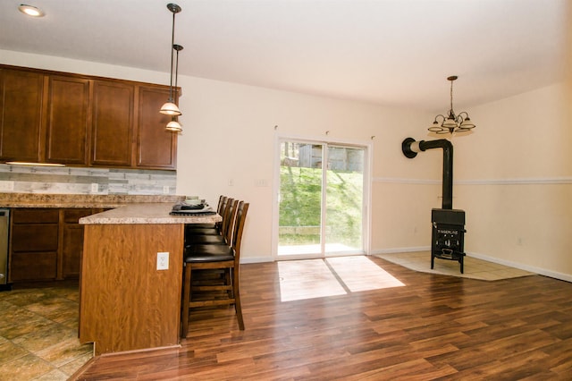 9839 Brunk Spring Ln, Broadway, VA 22815 - kitchen featuring a kitchen bar, light countertops, decorative light fixtures, and dark wood finished floors