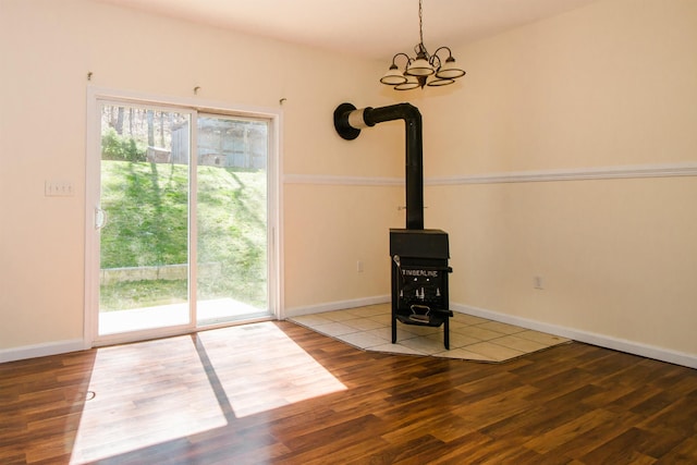 9839 Brunk Spring Ln, Broadway, VA 22815 - unfurnished living room with wood finished floors, a wood stove, healthy amount of natural light, and a chandelier