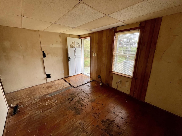 204 Dogwood St, Waynesboro, VA 22980 - unfurnished room featuring a drop ceiling, hardwood / wood-style floors, wood walls, and plenty of natural light