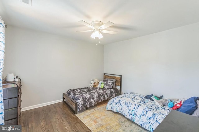 bedroom featuring ceiling fan, baseboards, and wood finished floors