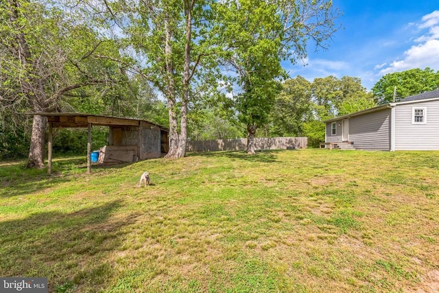 view of yard with an outdoor structure and fence