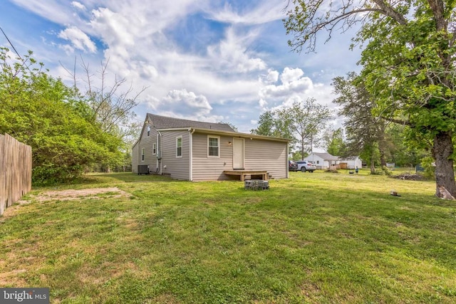 rear view of house with fence and a lawn