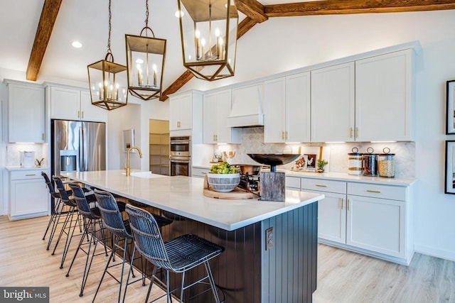 kitchen featuring custom range hood, a chandelier, stainless steel appliances, light wood-style flooring, and recessed lighting