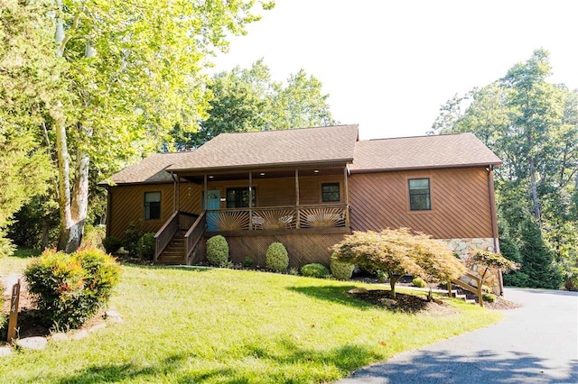 single story home with covered porch, stairway, a front yard, and stone siding