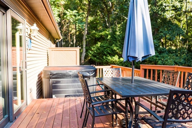 wooden terrace featuring a hot tub and outdoor dining area