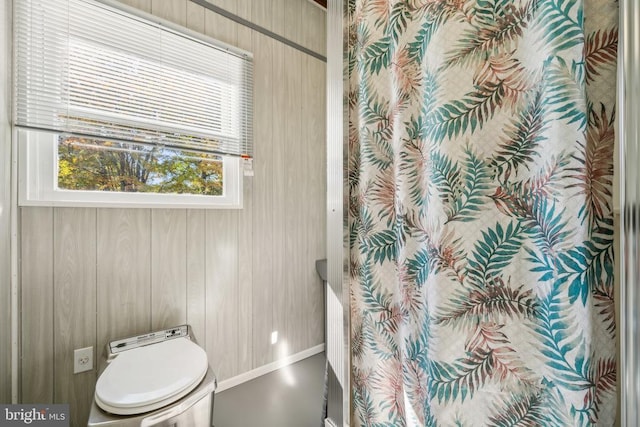 full bath featuring toilet, wooden walls, and curtained shower
