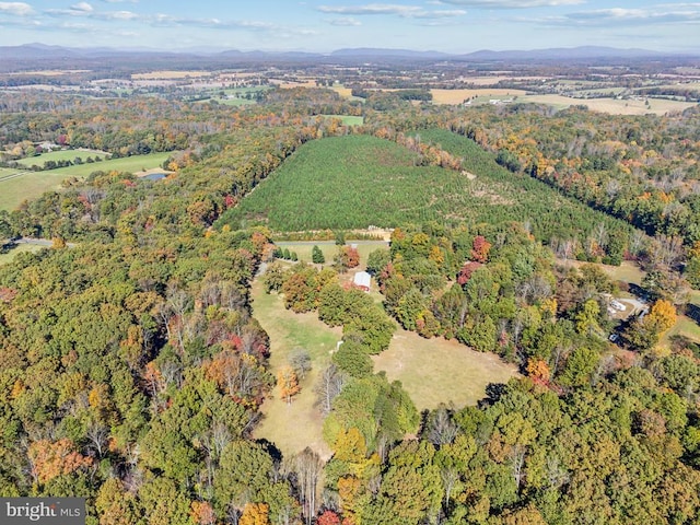 aerial view of property and surrounding area with a forest