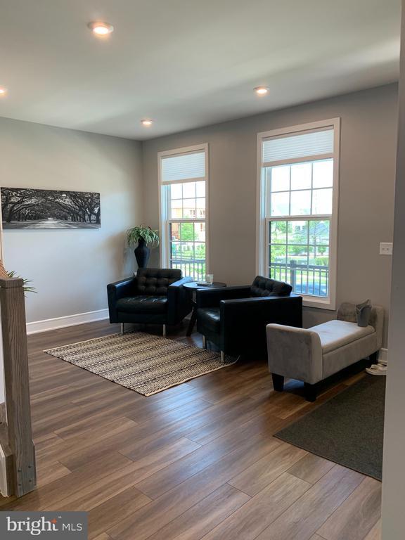  - living area with wood finished floors and recessed lighting