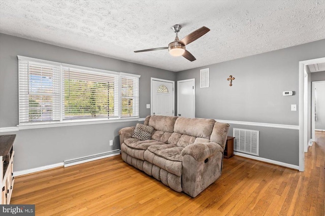 316 Grove Ave, Gordonsville, VA 22942 - living area featuring a baseboard heating unit, visible vents, a textured ceiling, and wood finished floors