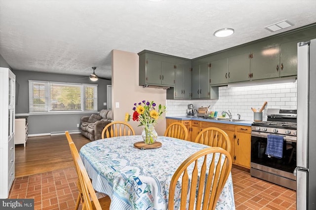 316 Grove Ave, Gordonsville, VA 22942 - kitchen featuring visible vents, decorative backsplash, brick patterned floor, baseboards, and appliances with stainless steel finishes