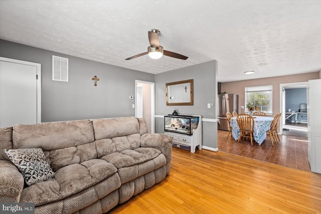 316 Grove Ave, Gordonsville, VA 22942 - living area with a textured ceiling, baseboards, ceiling fan, visible vents, and light wood-type flooring