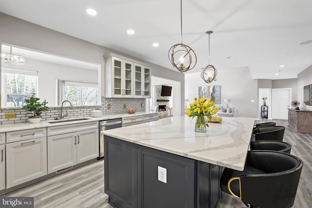 7806 Shawmont Rd, Fredericksburg, VA 22407 - kitchen with a sink, dishwasher, a chandelier, light wood-style floors, and tasteful backsplash