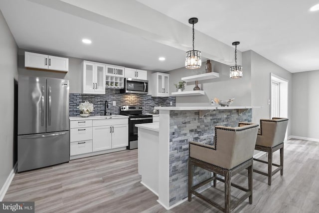 7806 Shawmont Rd, Fredericksburg, VA 22407 - kitchen with stainless steel appliances, light countertops, a kitchen bar, white cabinets, and baseboards