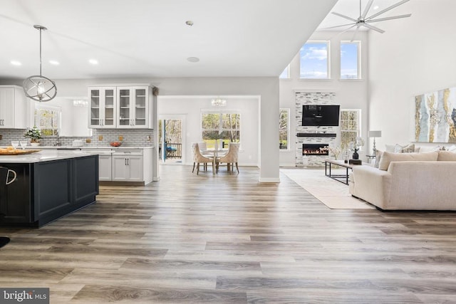 7806 Shawmont Rd, Fredericksburg, VA 22407 - kitchen featuring open floor plan, white cabinetry, light countertops, glass insert cabinets, and hanging light fixtures