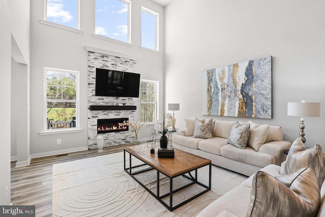 7806 Shawmont Rd, Fredericksburg, VA 22407 - living area with wood finished floors, a high ceiling, a tiled fireplace, and baseboards