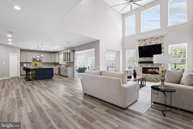 7806 Shawmont Rd, Fredericksburg, VA 22407 - living room featuring light wood finished floors, a fireplace, recessed lighting, a high ceiling, and baseboards