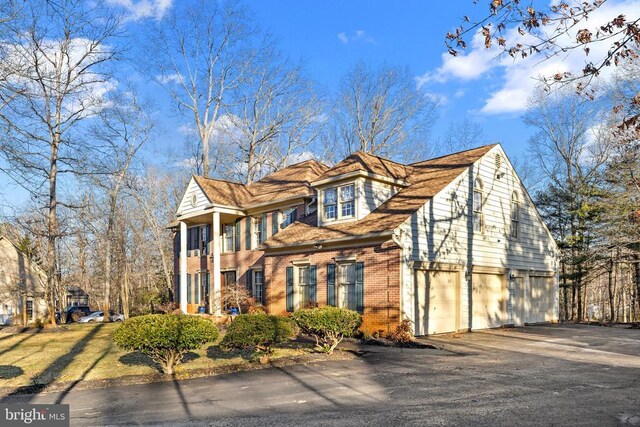 8413 Pathfinders Ct, Spotsylvania, VA 22553 - view of side of home featuring an attached garage, brick siding, and driveway