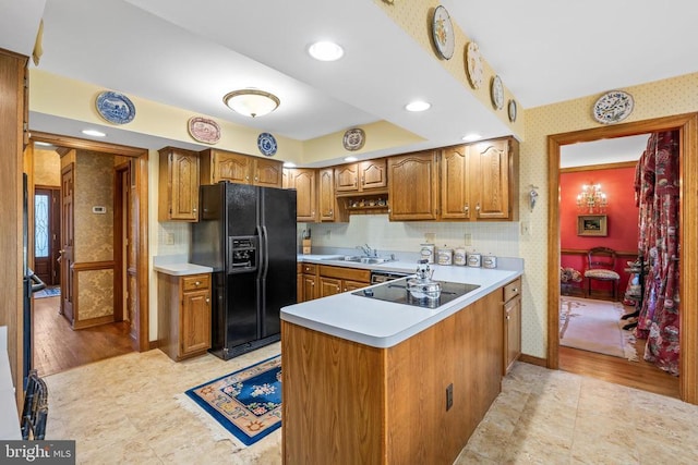 8413 Pathfinders Ct, Spotsylvania, VA 22553 - kitchen featuring a peninsula, a sink, wallpapered walls, black appliances, and light countertops