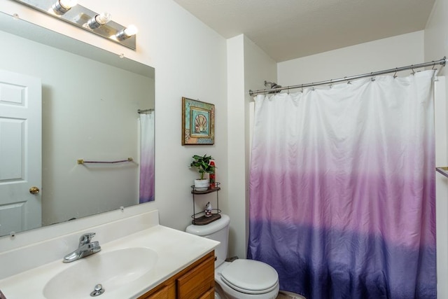 bathroom featuring vanity, toilet, and curtained shower